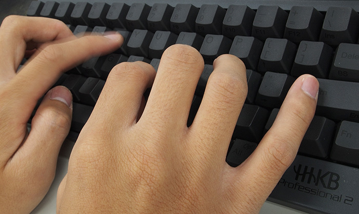 Fingers typing on keyboard.