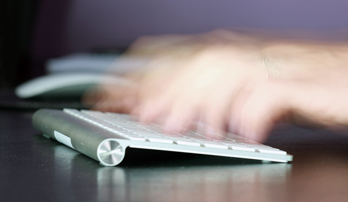 Close up of hands typing on a keyboard